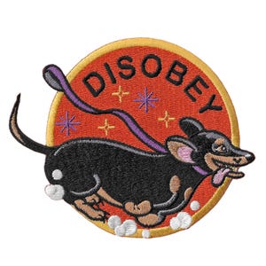 May include: Embroidered patch featuring a black dachshund dog with a purple leash, tongue out, and the word "DISOBEY" in white letters on a red circle with gold trim. Includes star and cross accents.