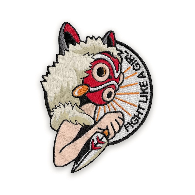 Puede incluir: Parche bordado que representa un personaje con una m&aacute;scara roja y orejas de lobo, sosteniendo un cuchillo. El parche tiene el texto "FIGHT LIKE A GIRL" en un dise&ntilde;o circular con rayos naranjas.