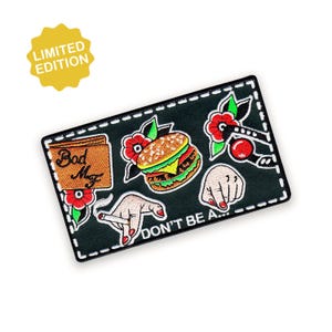 May include: A black embroidered patch featuring a burger, a hand holding a cigarette, and a fist. The patch has the text "DON'T BE A..." and "Bod Mz". A yellow "LIMITED EDITION" sticker is in the upper left corner.