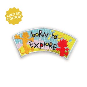 Könnte beinhalten: Gestickter Aufnäher mit den Worten "born to explore" in schwarzer Schrift. Der Aufnäher zeigt zwei Cartoonfiguren, eine orangefarbene und eine rote, auf hellblauem Hintergrund. Ein gelber "Limited Edition"-Aufkleber befindet sich in der oberen linken Ecke.