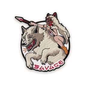 Peut inclure: Écusson brodé représentant un loup avec la gueule ouverte et une personne chevauchant son dos, tenant une lance. L'écusson a une bordure noire et le mot "SAVAGE" en lettres rouges.