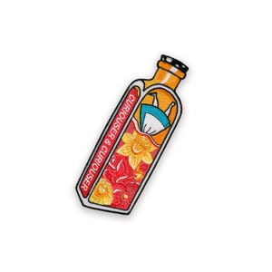 Könnte beinhalten: Gestickter Aufnäher mit einem Flaschendesign und dem Text "Curiouser & Curiouser". In der Flasche befindet sich ein Blumenarrangement und eine Figur in einem blauen Kleid. Der Aufnäher hat einen roten Rand und ist auf weißem Hintergrund.