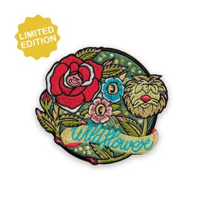 Puede incluir: Parche bordado con una rosa roja, flores azules y rosas y una flor caprichosa de color amarillo-marrón con una nariz roja. La palabra "wildflower" está bordada en turquesa. Una etiqueta amarilla de "Edición Limitada" está en la parte superior izquierda.