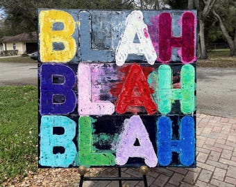 May include: A square canvas painting featuring the word BLAH repeated three times in a grid. The letters are rendered in thick, textured paint with a vibrant palette including yellow, grey, white, magenta, dark blue, pink, red, green, teal, and purple.