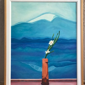 May include: A framed painting of a white flower in a brown vase against a blue and white mountain landscape.