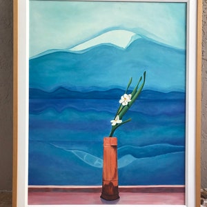 May include: A painting of a white flower in a brown vase against a blue and white mountain landscape.