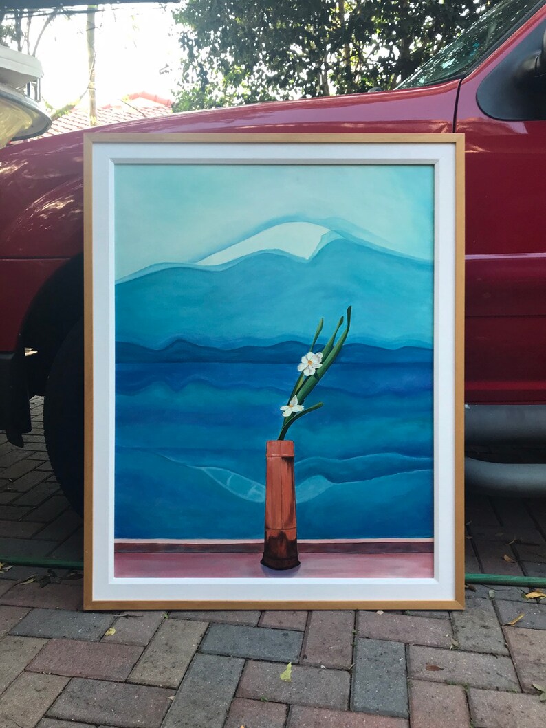 May include: A framed painting of a white flower in a brown vase against a blue and white mountain landscape.