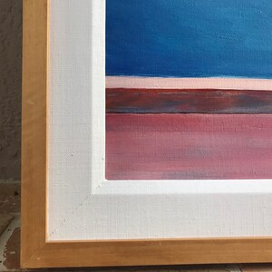 May include: A framed abstract painting with a blue background, a thin pink stripe, and a red and brown stripe at the bottom.