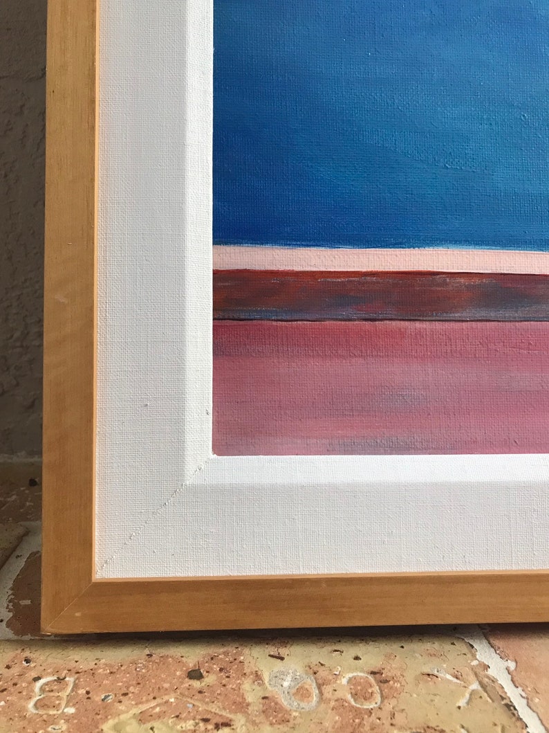 May include: A framed abstract painting with a blue background, a thin pink stripe, and a red and brown stripe at the bottom.