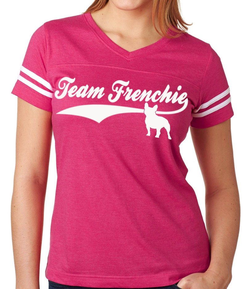 以下が含まれることがあります： ピンクと白の女性のTシャツに、フランスのブルドッグの白いグラフィックと「Team Frenchie」のテキストが描かれています。