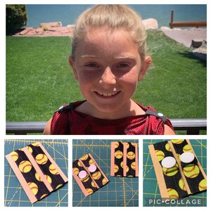 K&ouml;nnte beinhalten: Ein Set aus zwei schwarzen und gelben Softball-elastischen B&auml;ndern mit wei&szlig;en Kn&ouml;pfen. Die B&auml;nder sind auf einer braunen Oberfl&auml;che mit einem Gittermuster dargestellt. Die Kn&ouml;pfe sind separat auf einer wei&szlig;en Oberfl&auml;che dargestellt.