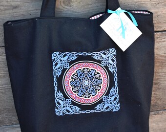 Impression antique de bloc russe brodée sur le coton noir lourd ; Doublure rouge/ivoire cochant avec deux grandes poches ; Fermeture magnétique