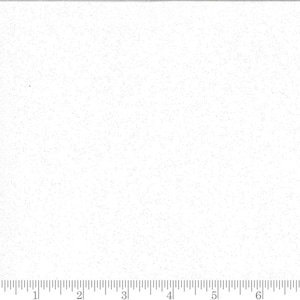 May include: White fabric with a speckled pattern. The fabric has a ruler printed along the bottom edge, with markings in inches. The fabric is likely used for quilting or sewing projects.