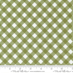 May include: A white fabric with a green gingham pattern. The fabric is a Moda fabric and the website is listed as www.modafabrics.com.