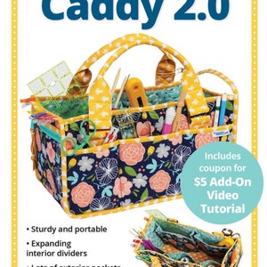 May include: A yellow and blue fabric caddy with a floral print and multiple pockets. The caddy has a zippered closure and padded handles. The text "Catch All Caddy 2.0" is at the top of the image. The text "Includes coupon for $5 Add-On Video Tutorial" is in the lower right corner of the image.