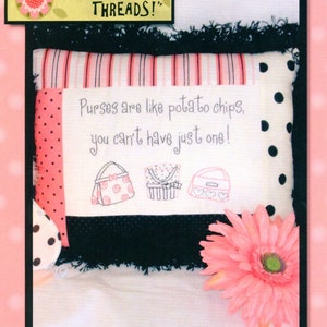 May include: A decorative pillow with the text "Purses are like potato chips, you can't have just one!" and three purse illustrations. The pillow has a black fringe, pink polka dot and striped fabric accents, and a pink flower.