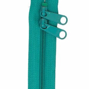 May include: A teal zipper with two pull tabs. The zipper is closed and ready to be sewn into a garment.
