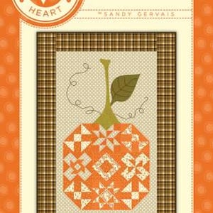 May include: A quilt pattern featuring an orange pumpkin design with a green stem and leaf. The pumpkin is made of various geometric shapes in orange and white. The text "Enormous" is displayed above the pumpkin image.