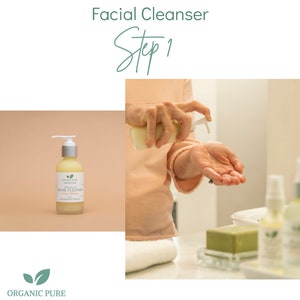 May include: A person's hand is shown pouring a clear liquid from a bottle labeled "Organic Pure Creations All Natural Facial Cleanser Orange Blossom" into their other hand. The bottle is on a light brown surface. The text "Facial Cleanser Step 1" is at the top of the image.