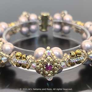May include: A beaded bracelet with a gold and silver design. The bracelet features a variety of beads, including pearls, crystals, and gold beads. The bracelet is accented with a pink crystal.