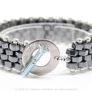 May include: A silver and gray beaded bracelet with a metal screw and washer clasp. The bracelet is made with small square beads and round beads.