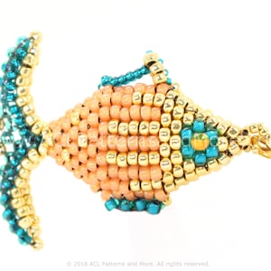 May include: A beaded fish charm with a peach-coloured body, gold and turquoise accents, and a gold clasp.