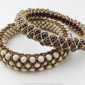 Könnte beinhalten: Zwei Perlenarmbänder, eines mit weißen und goldenen Perlen und das andere mit burgunderfarbenen und goldenen Perlen. Die Armbänder sind übereinander gestapelt.