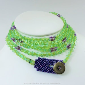 May include: A multi-strand beaded necklace in light green, with small purple accents. The necklace has a dark blue beaded clasp and a bronze-coloured button fastening. The necklace is displayed on a white mannequin.