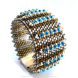 May include: A beaded bracelet with a geometric pattern in gold, silver, and blue. The bracelet is made with small seed beads and features a row of blue crystals.