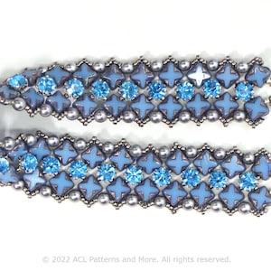 May include: A blue and silver beaded bracelet with a silver clasp. The bracelet is made with small, round beads and larger, square beads with a star design.