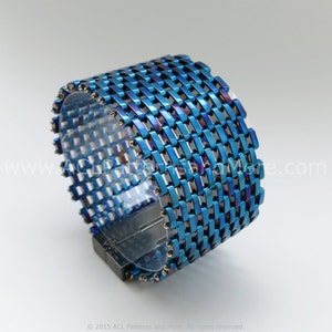 May include: A blue and iridescent metal bracelet with a woven design. The bracelet has a magnetic clasp.