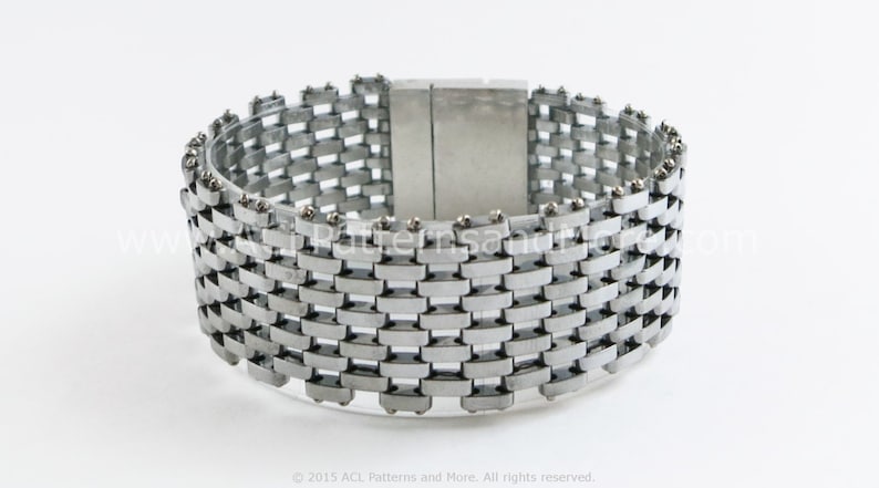 May include: A silver metal bracelet with a woven design and a magnetic clasp.