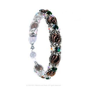 May include: A silver and copper beaded bracelet with green crystal accents. The bracelet features a repeating pattern of copper leaves and green crystals.