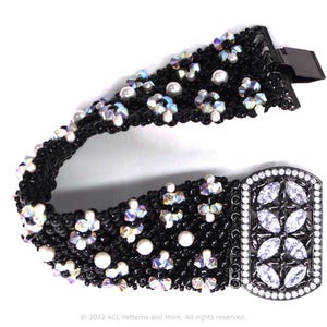 May include: A black beaded bracelet with a silver clasp. The bracelet is decorated with iridescent beads and white pearls. The clasp is adorned with clear rhinestones.