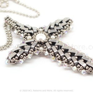 May include: A silver beaded necklace with a large silver and white cross pendant. The cross is made of small beads and has a large white pearl in the center.