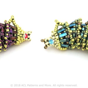 May include: Two beaded fish ornaments. One is purple and gold, the other is teal and gold. Both have a fish shape with a tail and a head with a small red or blue accent. The beads are small and tightly woven.