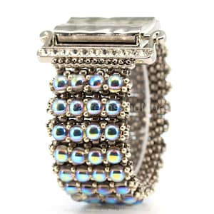 May include: A silver bracelet with a clasp and iridescent blue beads. The bracelet is made of small beads and has a silver clasp.