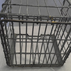 Puede incluir: Una caja de alambre de metal vintage con forma rectangular. La caja est&aacute; hecha de malla de alambre y tiene un asa en la parte superior. La caja es gris y tiene algunas manchas de &oacute;xido.