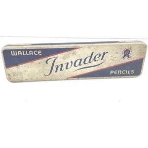 May include: Vintage rectangular pencil case with the text "WALLACE Invader PENCILS" in blue and red on a cream background. The case has a worn, aged appearance, suggesting it is an antique item.