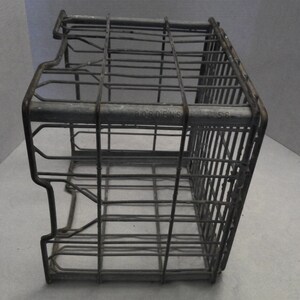 Puede incluir: Una caja de alambre de metal vintage con las palabras "Borden's 56" impresas en el lateral. La caja est&aacute; hecha de metal galvanizado y tiene una forma rectangular.