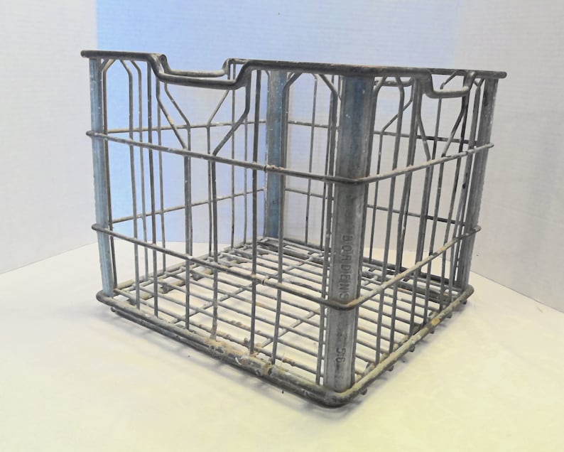 Puede incluir: Una caja de metal vintage con un dise&ntilde;o de malla de alambre. La caja est&aacute; pintada de plata y tiene las palabras "BLORDIENS CO." impresas en el lateral.