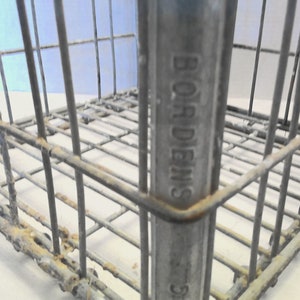 Puede incluir: Una caja de metal vintage con las palabras "BORDENS" en relieve en el lateral. La caja est&aacute; hecha de malla de alambre y tiene una p&aacute;tina oxidada.