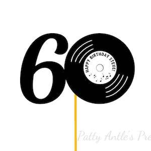 May include: A black cake topper featuring the number 60, where the zero is designed as a vinyl record. The record center label is white with the text HAPPY BIRTHDAY STEVE! and small musical notes. The topper is attached to a thin yellow stick.