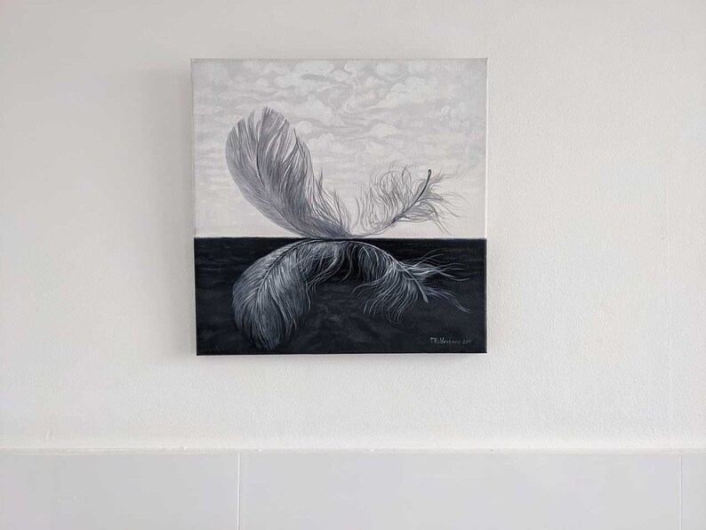 May include: A black and white painting of two feathers, one on top of the other, with a white background on top and a black background on the bottom. The feathers are in a mirrored position, with the top feather pointing to the right and the bottom feather pointing to the left.
