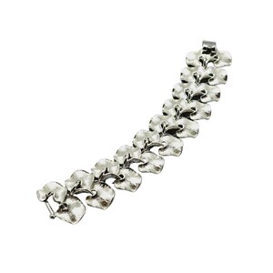 May include: A silver bracelet with a chain of linked leaf-shaped links.