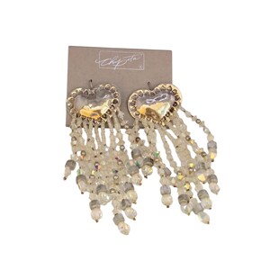 May include: Heart-shaped earrings with gold-tone metal and beaded fringe. The earrings have a textured gold heart design with a beaded fringe of clear and iridescent beads. The earrings are attached to a gray card with a signature.