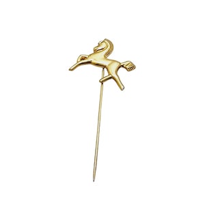May include: A gold-colored horse pin with a long, thin stem. The horse is rearing up on its hind legs with its head turned to the side.