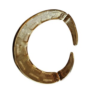 May include: A gold-toned, open-ended collar necklace with a textured interior surface. The necklace has a hinged clasp and a curved, crescent shape. The metal has a brushed finish, and the design is simple and elegant.