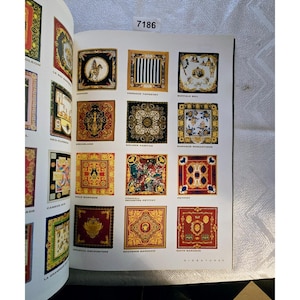 May include: A catalogue page showcasing a collection of square silk scarves with detailed patterns. The scarves feature a variety of colours, including gold, black, red, and blue, with designs like stripes, floral arrangements, and equestrian themes. The page is numbered 7186 at the top.