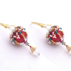 May include: A pair of red, white, and green beaded earrings with gold accents and crystal drops.